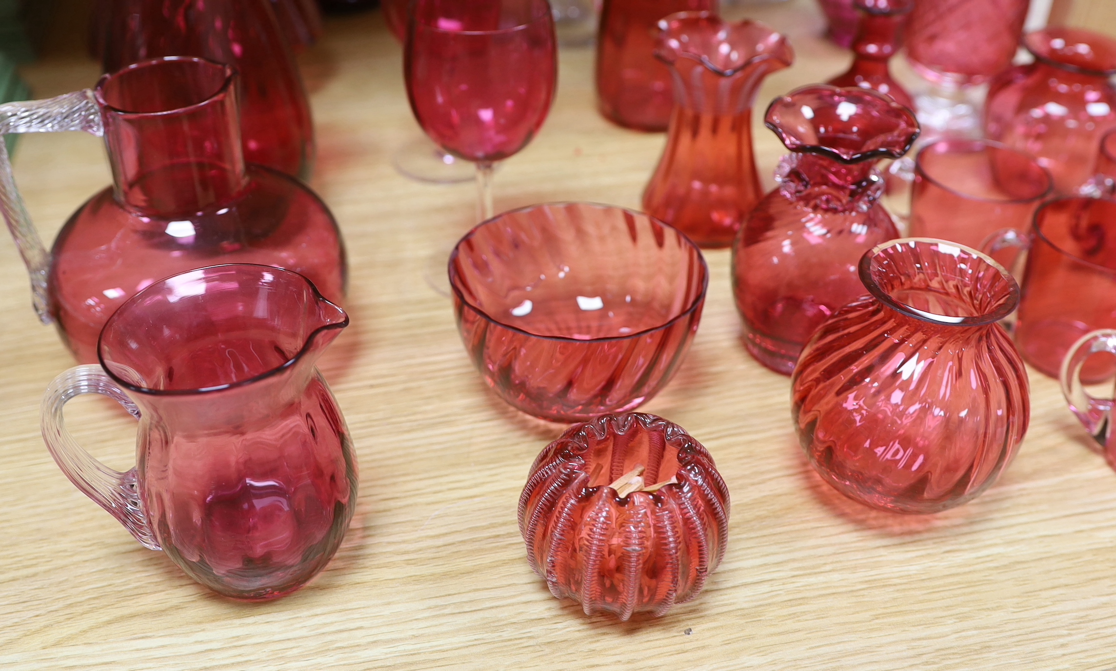 Cranberry glassware including vases, jugs, bowls and custard cups, the largest 33cm high